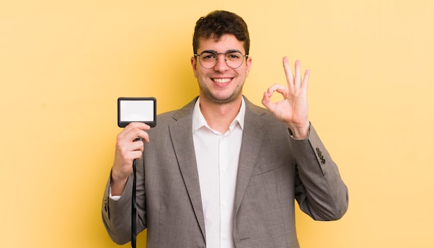 Young handsome man feeling happy showing approval with okay gesture vip pass concept