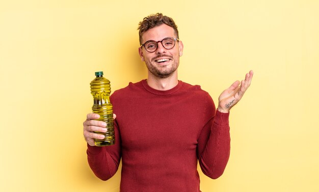 Young handsome man feeling happy, surprised realizing a solution or idea. olive oil concept