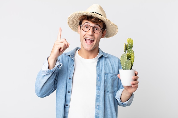 young handsome man feeling like a happy and excited genius after realizing an idea. farmer holding a decorative cactus