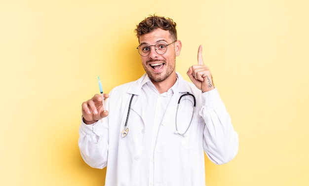 Young handsome man feeling like a happy and excited genius after realizing an idea. physician syringe concept