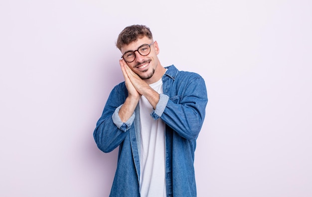 Young handsome man feeling in love and looking cute, adorable and happy, smiling romantically with hands next to face