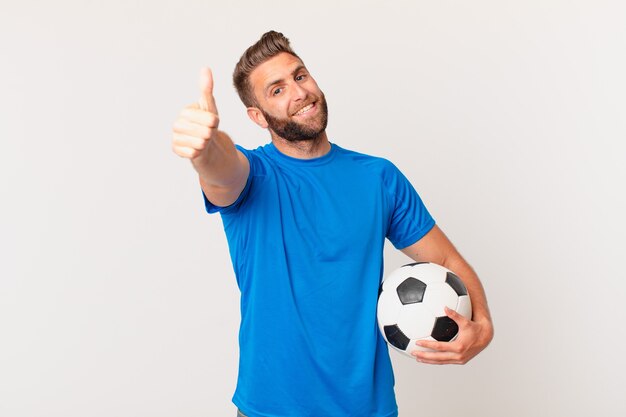 Young handsome man feeling proud,smiling positively with thumbs up. soccer concept