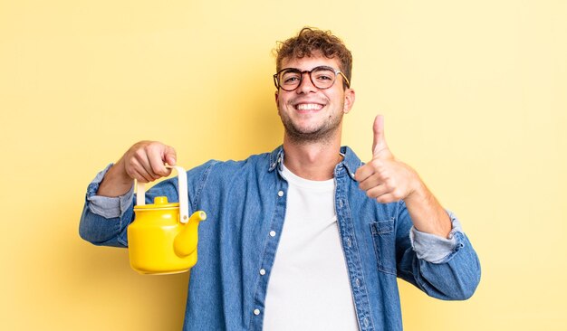 Young handsome man feeling proud,smiling positively with thumbs up.teapot concept