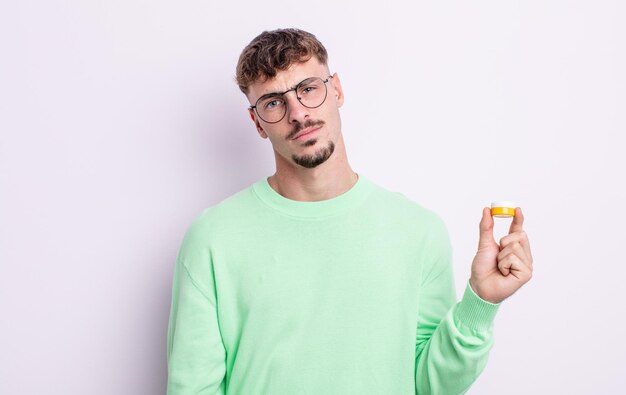 Young handsome man feeling puzzled and confused. contact lenses