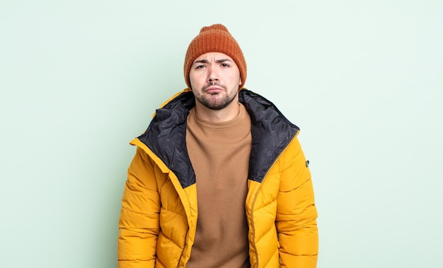 Young handsome man feeling sad and whiney with an unhappy look and crying. cold weather concept