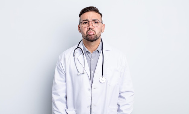 Young handsome man feeling sad and whiney with an unhappy look and crying. physician concept