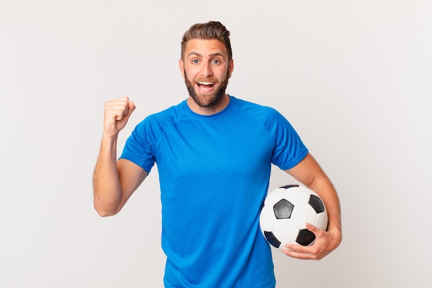 若いハンサムな男はショックを受け、笑い、成功を祝っています。サッカーのコンセプト