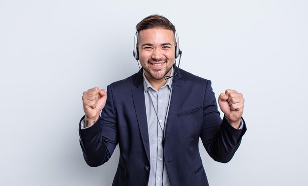 Young handsome man feeling shocked,laughing and celebrating success. telearketer concept