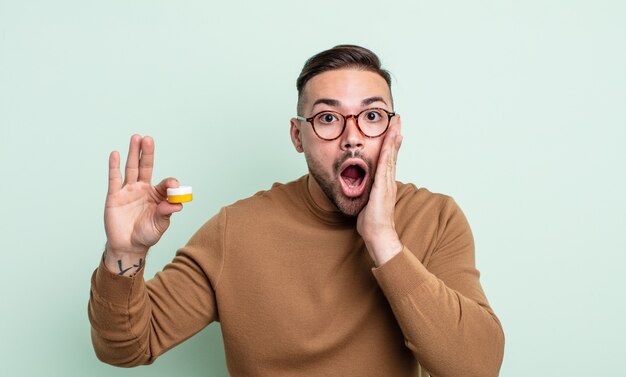 Young handsome man feeling shocked and scared. contact lens