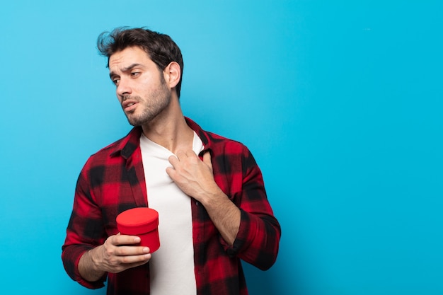 Giovane bell'uomo che si sente stressato, ansioso, stanco e frustrato, tira il collo della camicia, sembra frustrato dal problema