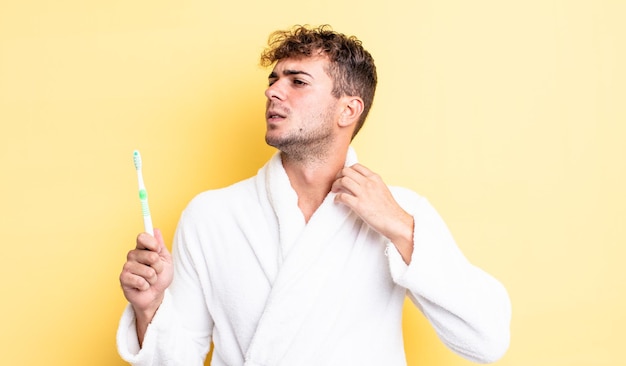 Young handsome man feeling stressed, anxious, tired and frustrated. toothbrush concept