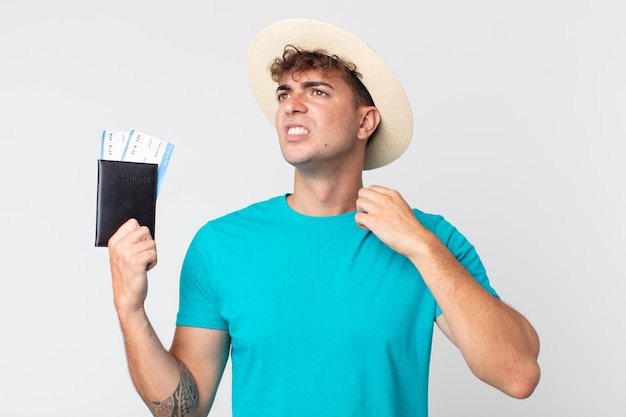 Young handsome man feeling stressed, anxious, tired and frustrated. traveler holding his passport