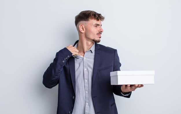 Young handsome man feeling stressed, anxious, tired and frustrated. white box package