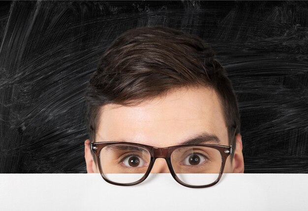 Young handsome man in glasses on white tale background