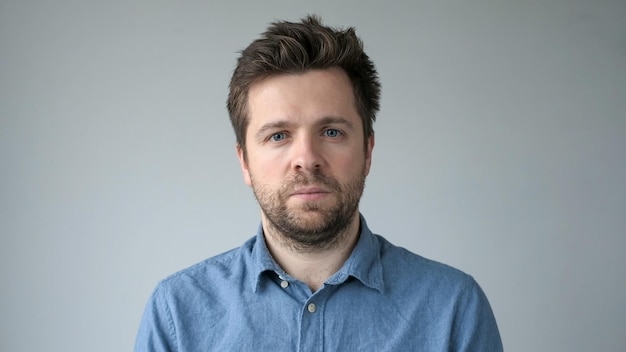 Young handsome man has serious expression poses in studio