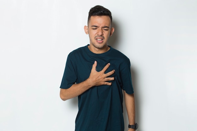 Young handsome man having heart attack isolated on white background