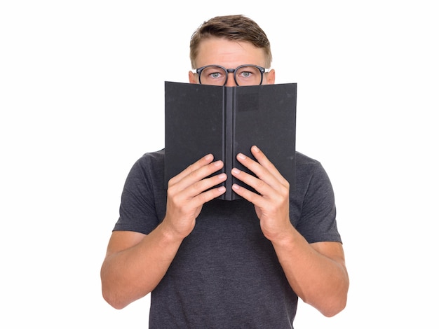 young handsome man hiding behind book