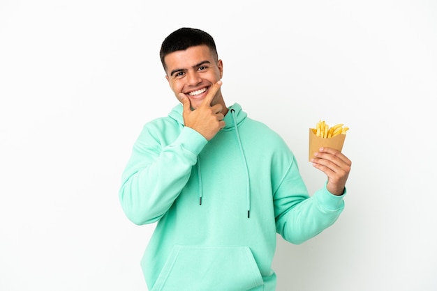 Young handsome man holding fried chips over isolated white background happy and smiling