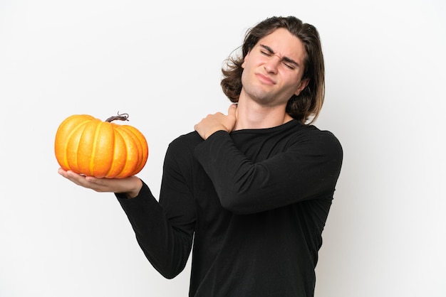 Young handsome man holding a pumpkin isolated on white background suffering from pain in shoulder for having made an effort