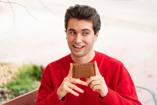 Young handsome man holding a wallet