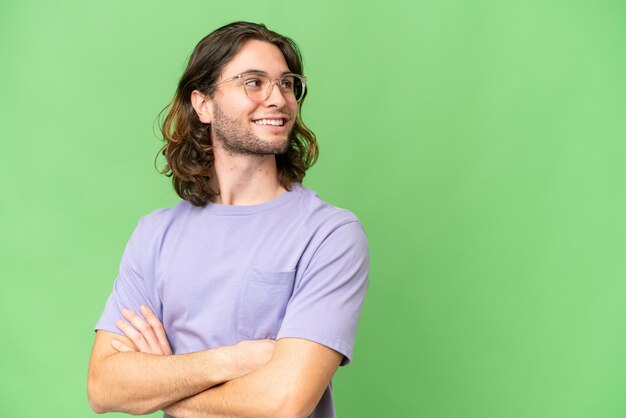 Young handsome man over isolated background looking to the side and smiling