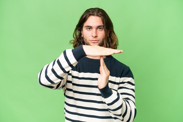 Young handsome man over isolated background making time out gesture