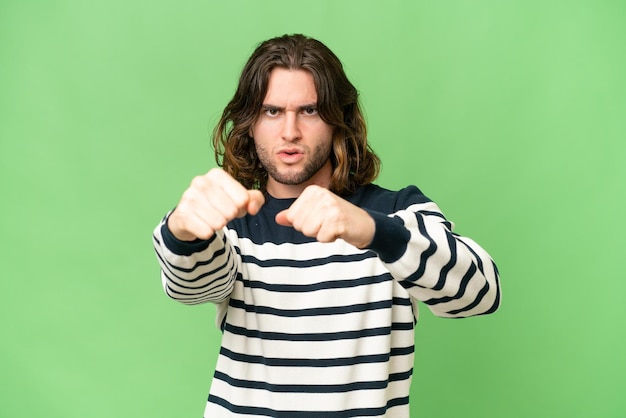 Young handsome man over isolated background with fighting gesture