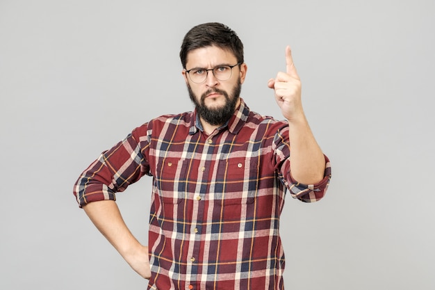 Young handsome man over isolated gray  background pointing with finger up