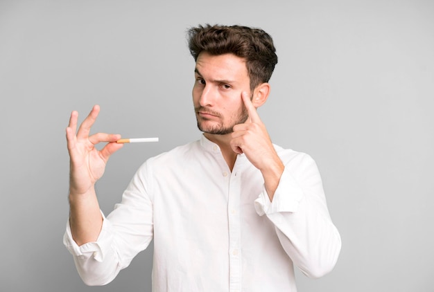 Young handsome man isolated and holding a cigarette