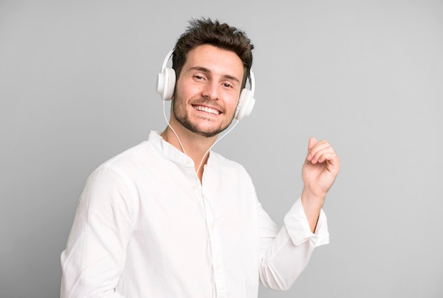 Young handsome man isolated listening music and dancing with his headphones