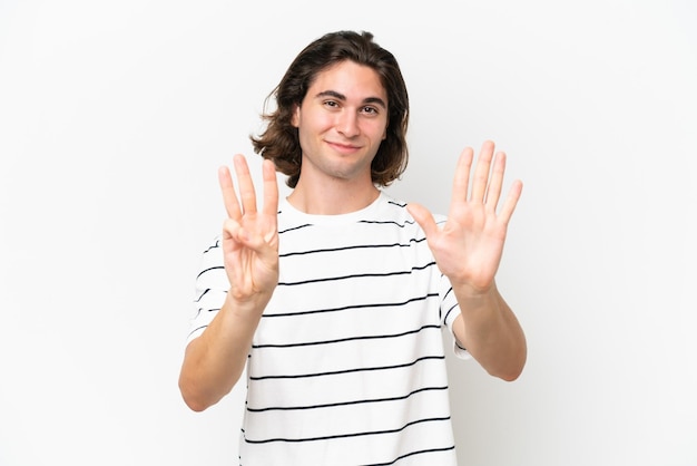 Young handsome man isolated on white background counting eight with fingers