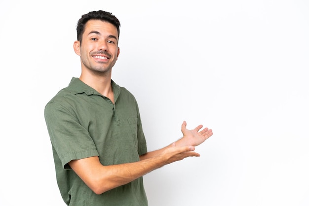 Young handsome man over isolated white background extending hands to the side for inviting to come