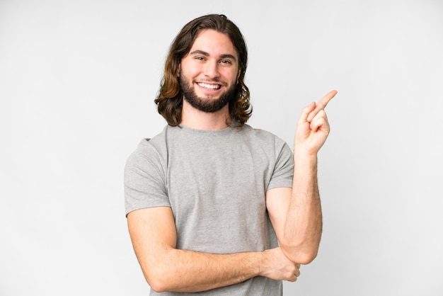 Young handsome man over isolated white background happy and pointing up