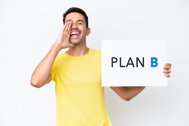 Young handsome man over isolated white background holding a placard with the message PLAN B and shouting