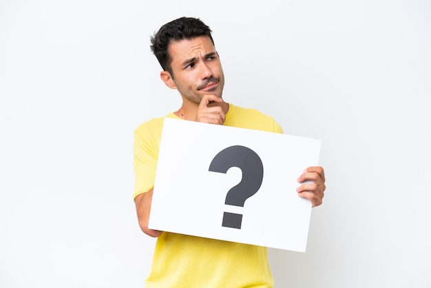 Young handsome man over isolated white background holding a placard