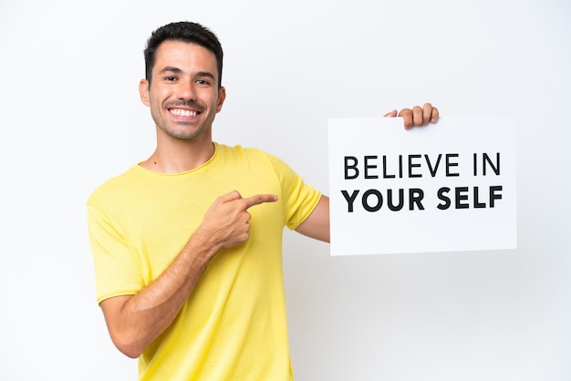 Young handsome man over isolated white background holding a placard
