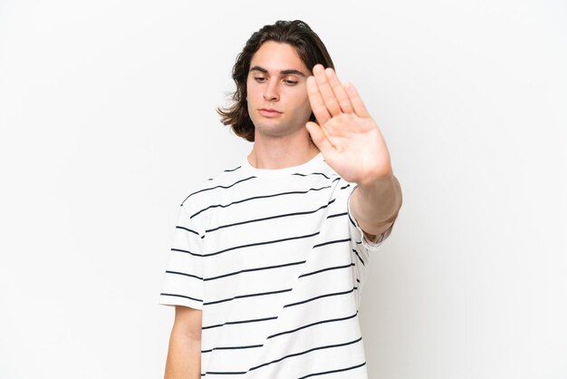 Young handsome man isolated on white background making stop gesture and disappointed