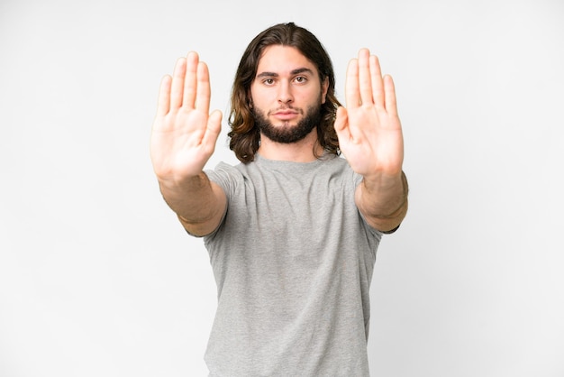 Young handsome man over isolated white background making stop gesture and disappointed
