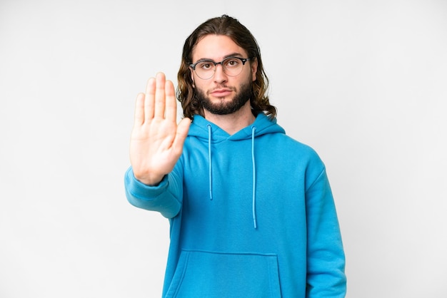 Young handsome man over isolated white background making stop gesture