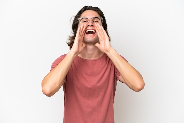 Young handsome man isolated on white background shouting and announcing something