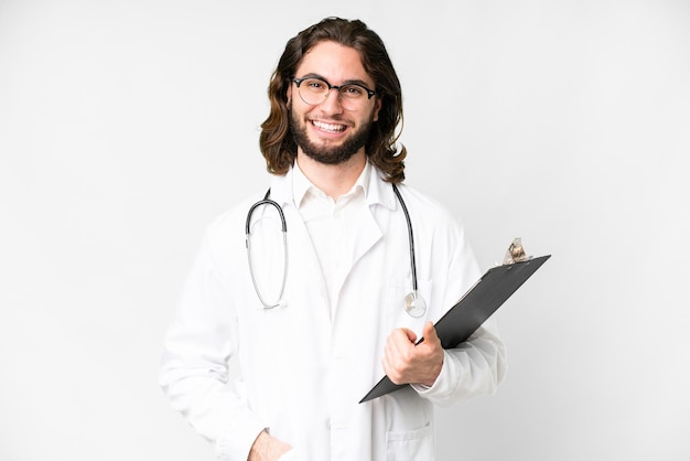 Молодой красивый мужчина на изолированном белом фоне в врачебном халате и с папкой в руках