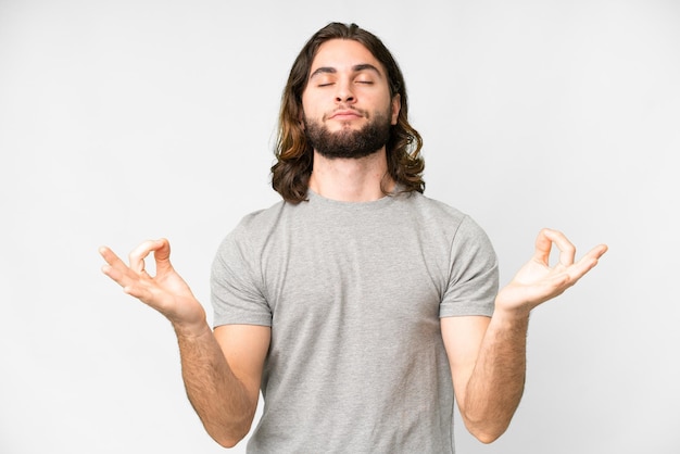 Young handsome man over isolated white background in zen pose