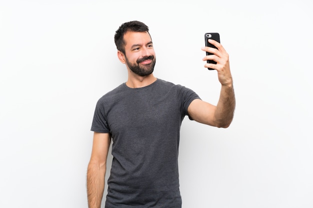 Young handsome man over isolated white making a selfie