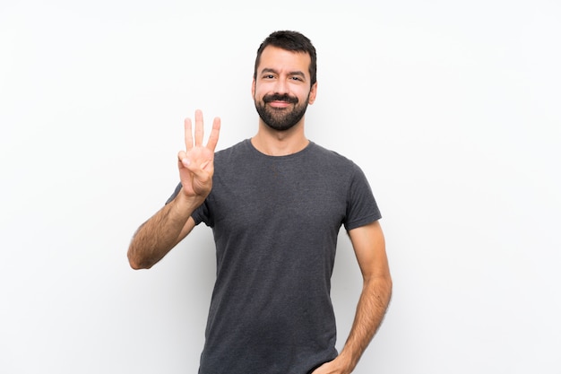 Young handsome man over isolated white wall happy and counting three with fingers