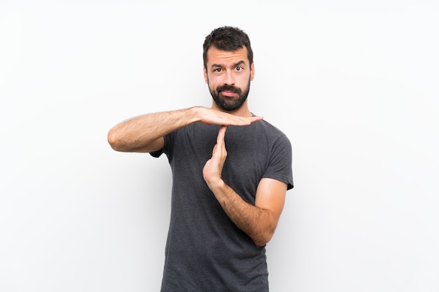 Young handsome man over isolated white wall making time out gesture