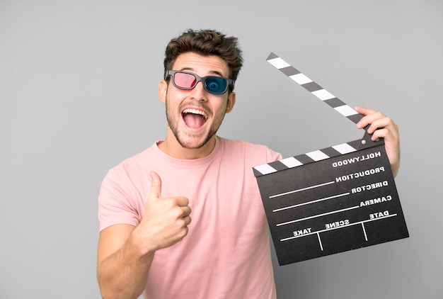 Young handsome man isolated with a cinema clapper and virtual reallity glases movie or film concept