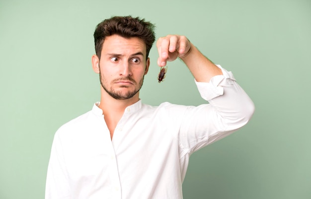 Young handsome man isolated with cockroachs