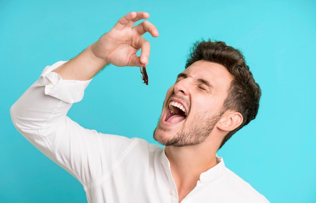 Young handsome man isolated with cockroachs