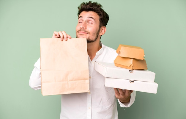 Young handsome man isolated with fast food mock up boxes delivery and take away concept