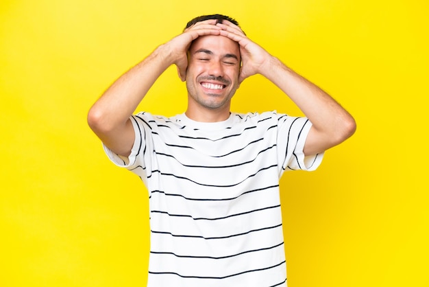 Young handsome man over isolated yellow background laughing